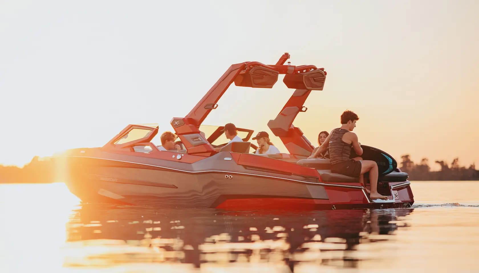 A MasterCraft towboat on the water at sunset